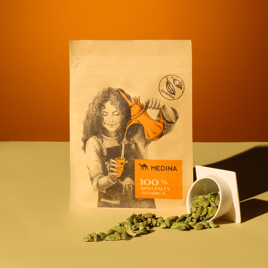 Cardamon Beans with product packaging and arabic coffee cup